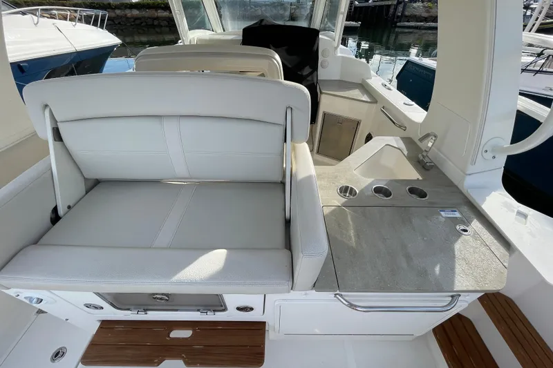 Slide: The Image of 2022 Boston Whaler 350 Realm interior with seating and kitchenette area. - 12