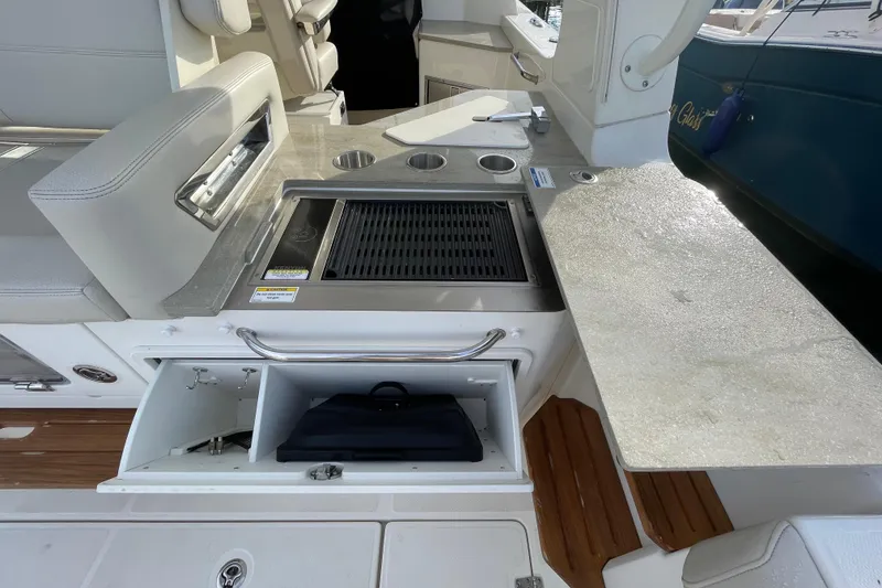 Slide: The Image of Boston Whaler 350 Realm 2022 boat interior with grill and storage compartments. - 13