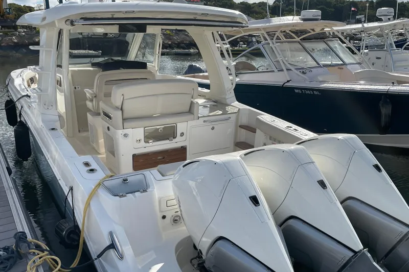 Slide: The Image of 2022 Boston Whaler 350 Realm boat docked, featuring triple outboard engines. - 19