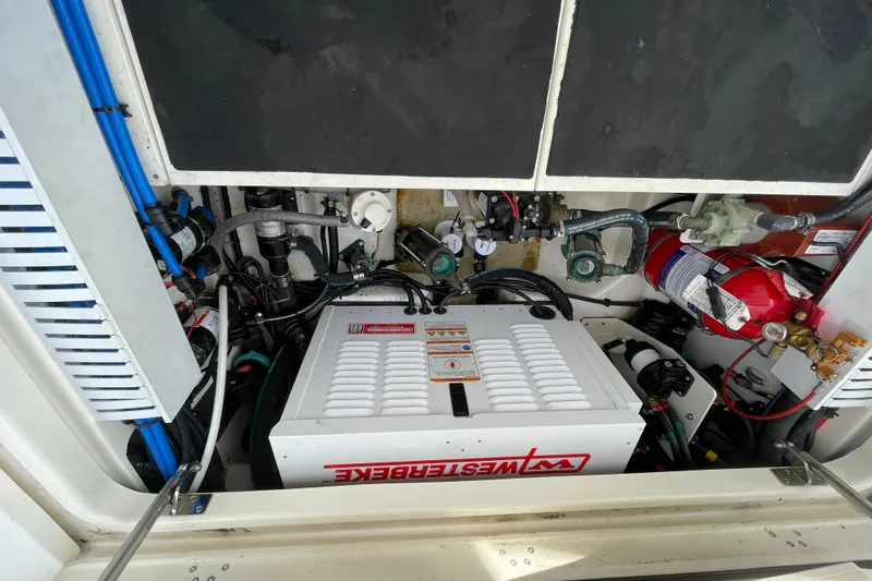 Slide: The Image of Engine compartment of 2022 Boston Whaler 350 Realm with Westerbeke generator and fire extinguisher. - 22
