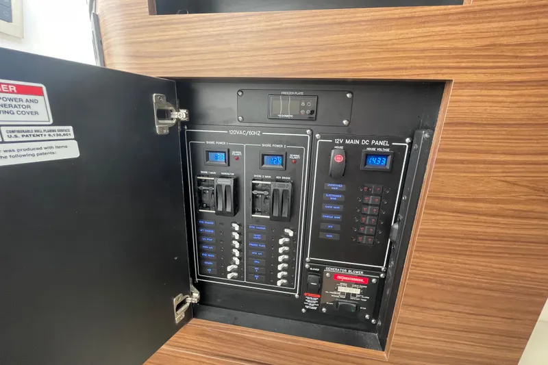 Slide: The Image of Electrical panel inside 2022 Boston Whaler 350 Realm boat, featuring various switches and controls. - 28