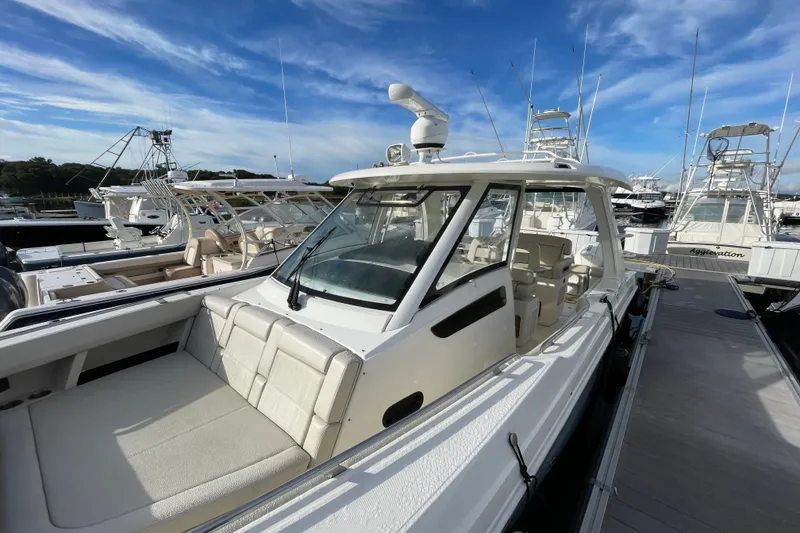 Slide: The Image of 2022 Boston Whaler 350 Realm boat docked at marina under blue sky. - 29