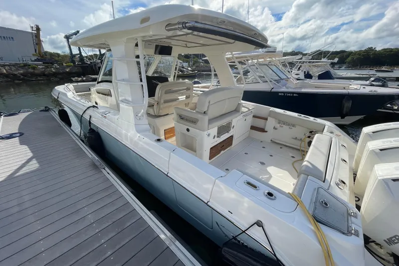 Slide: The Image of 2022 Boston Whaler 350 Realm boat docked at a marina with clear skies. - 4