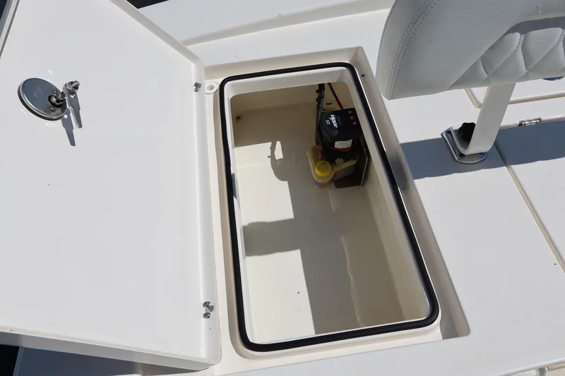 Slide: The Image of Open storage compartment on 2024 Pathfinder 2300 HPS boat, featuring a battery and wiring. - 10