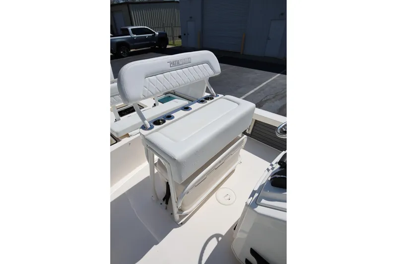 Slide: The Image of 2024 Pathfinder 2300 HPS boat seat with cup holders in a parking lot setting. - 18