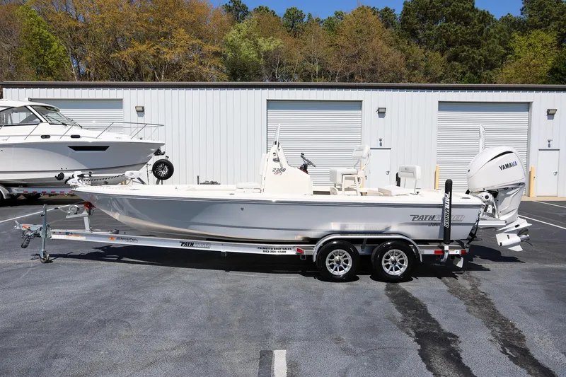 Slide: The Image of 2024 Pathfinder 2300 HPS boat on trailer, parked outdoors near storage facility. - 4