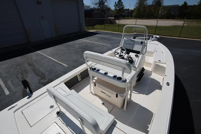 Slide: The Image of 2024 Pathfinder 2300 HPS boat interior with steering console and seating in a parking lot. - 6