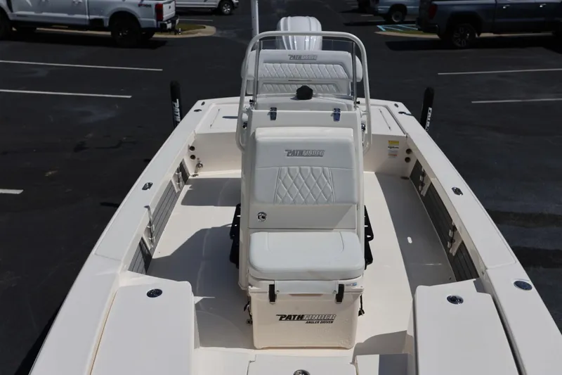Slide: The Image of 2024 Pathfinder 2300 HPS boat interior with seating and console in a parking lot. - 9