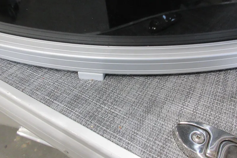 Slide: The Image of Close-up of 2026 Sun Tracker SportFish 22 DLX boat detail, featuring metal trim and textured surface. - 17