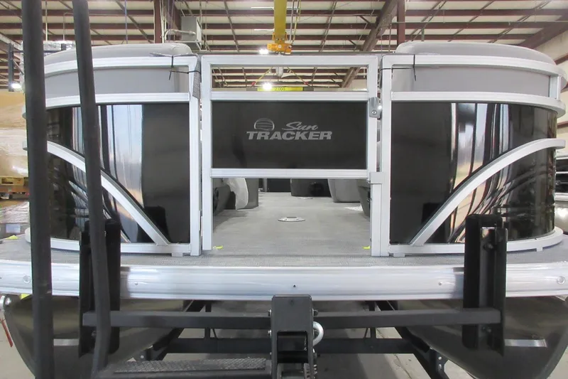 Slide: The Image of 2026 Sun Tracker SportFish 22 DLX pontoon boat in a warehouse setting. - 2