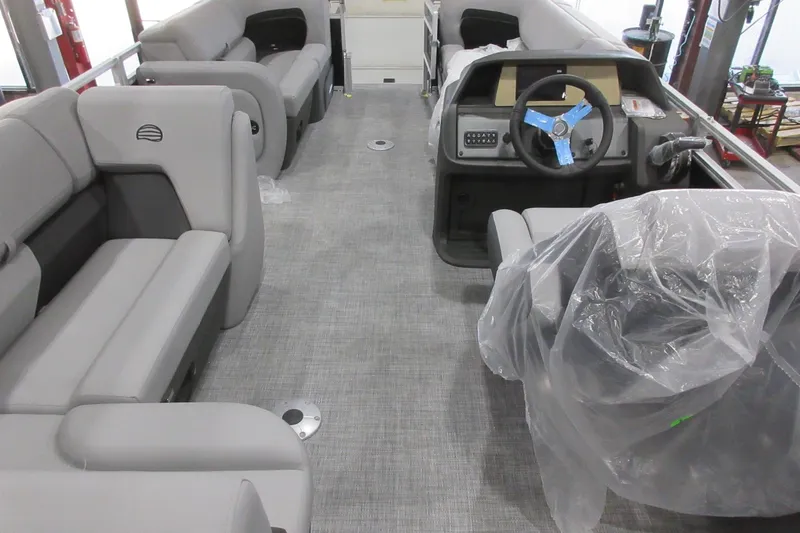Slide: The Image of 2026 Sun Tracker SportFish 22 DLX pontoon boat interior with gray seating and steering console. - 5