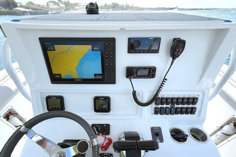 Slide: The Image of 2003 Marlago FS 35 Center Console boat dashboard with navigation and communication equipment. - 14