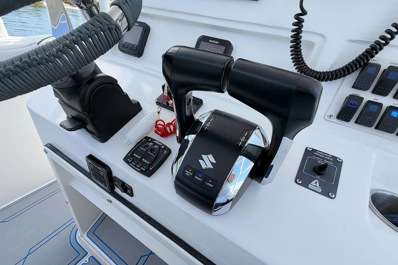Slide: The Image of Center console controls of a 2003 Marlago FS 35 boat, featuring steering and throttle. - 15