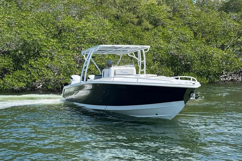 Slide: The Image of 2003 Marlago FS 35 Center Console boat cruising near lush green mangroves. - 4