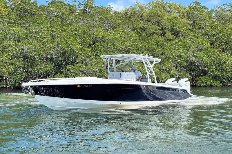 Slide: The Image of 2003 Marlago FS 35 Center Console boat cruising near lush green mangroves. - 7