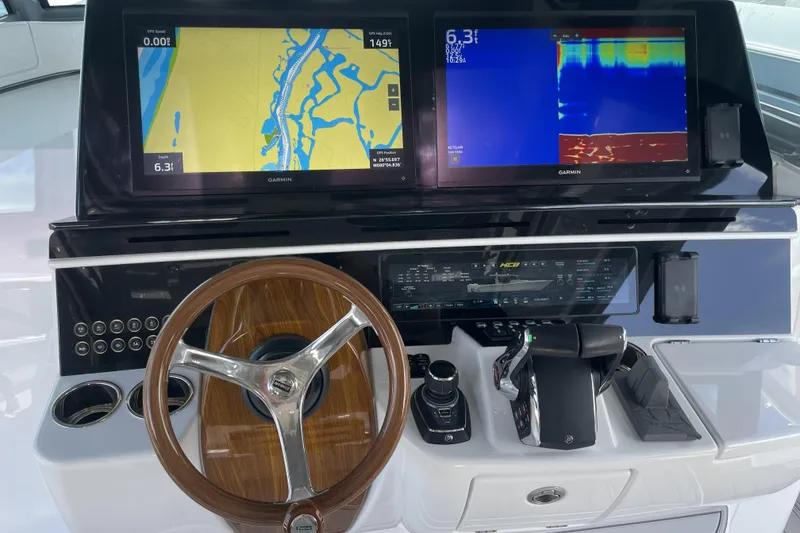 Slide: The Image of Helm of 2025 HCB 56 Suenos with dual Garmin displays and wooden steering wheel. - 15