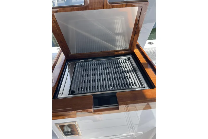 Slide: The Image of Built-in grill on the 2025 HCB 56 Suenos yacht, featuring a sleek wooden finish. - 11
