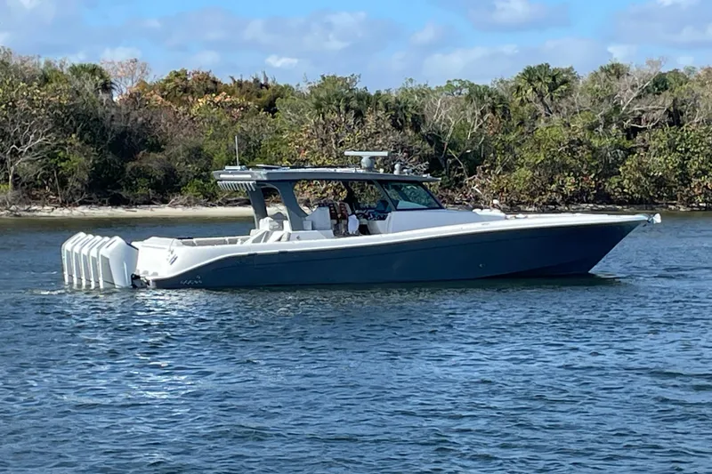 Slide: The Image of 2025 HCB 56 Suenos boat cruising on a calm river near lush greenery. - 4