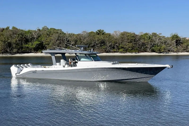 Slide: The Image of 2025 HCB 56 Suenos luxury boat on calm water, surrounded by lush greenery. - 3