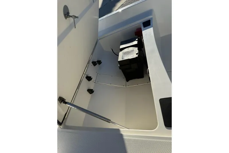 Slide: The Image of 2025 Mako Pro Skiff 15 CC storage compartment with battery and hydraulic support. - 10