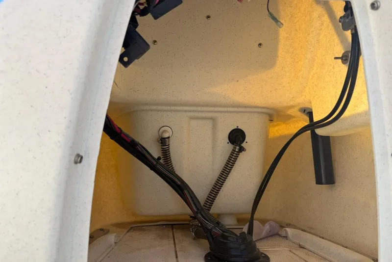 Slide: The Image of Interior view of a 2025 Mako Pro Skiff 15 CC boat compartment with wiring and hoses. - 5