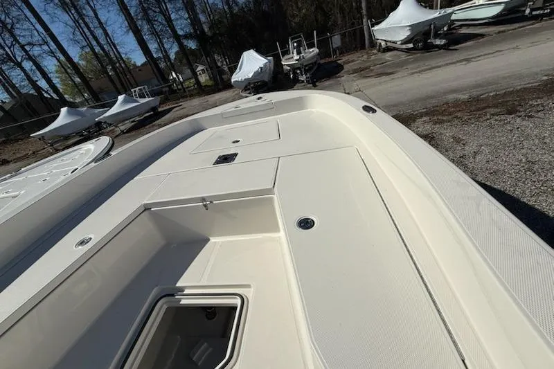 Slide: The Image of 2025 Ranger 2360 Bay boat deck with storage compartments, parked outdoors. - 12