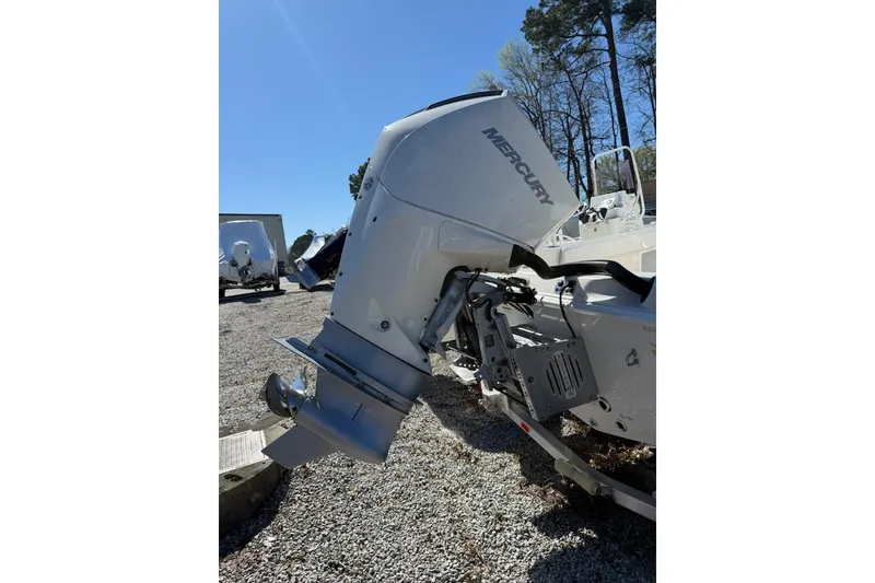 Slide: The Image of 2025 Ranger 2360 Bay boat with Mercury outboard motor in a sunny outdoor setting. - 14