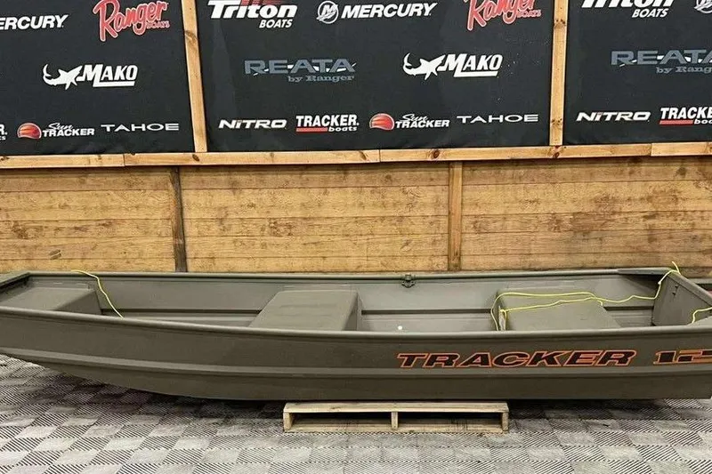 The Image of 2026 Tracker Grizzly 12 Jon boat displayed indoors with branded backdrop. - 1