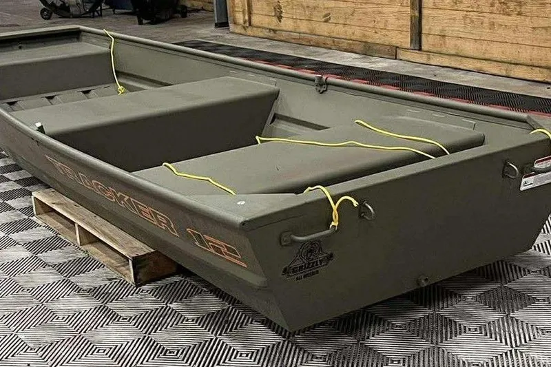 Slide: The Image of 2026 Tracker Grizzly 12 Jon boat on display, featuring durable design and seating. - 4