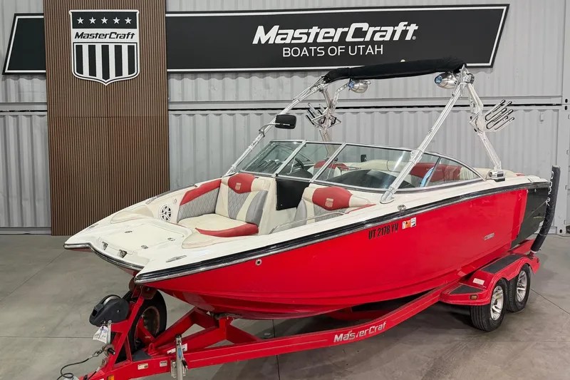 The Image of 2008 MasterCraft X-35 boat in showroom, red and white design, on trailer. - 1