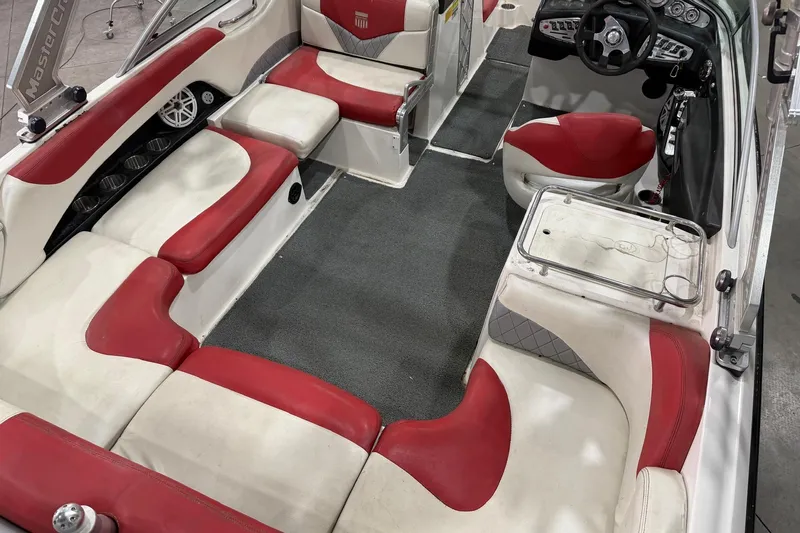 Slide: The Image of 2008 MasterCraft X-35 boat interior with red and white seating, steering wheel, and cup holders. - 6