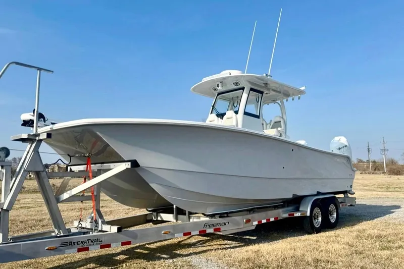 The Image of 2023 Freeman 28 boat on trailer under clear blue sky. - 0