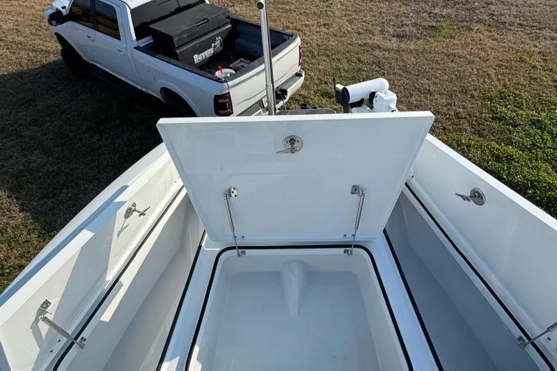 Slide: The Image of Open storage compartment on a 2023 Freeman 28 boat, with a truck in the background. - 12
