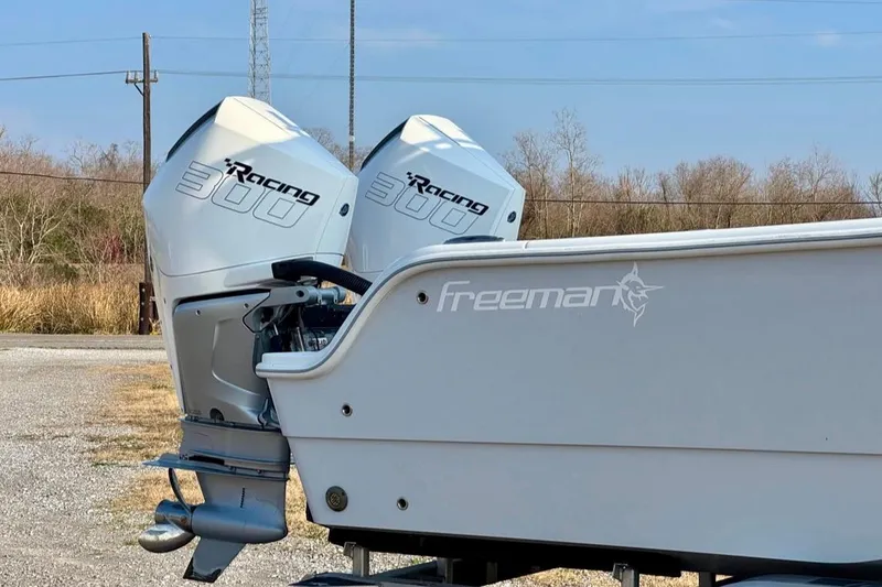Slide: The Image of Freeman 28 boat with twin Racing 300 engines, 2023 model, parked outdoors. - 2