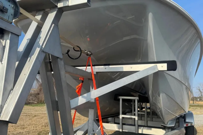 Slide: The Image of 2023 Freeman 28 boat on trailer, secured with orange straps, viewed from below. - 22