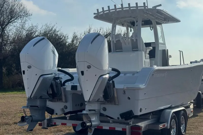 Slide: The Image of 2023 Freeman 28 boat with dual outboard motors on a trailer. - 3