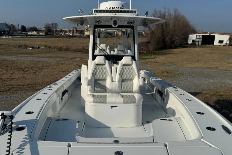 Slide: The Image of 2023 Freeman 28 boat with white seating and Garmin electronics, parked on grassy area. - 7