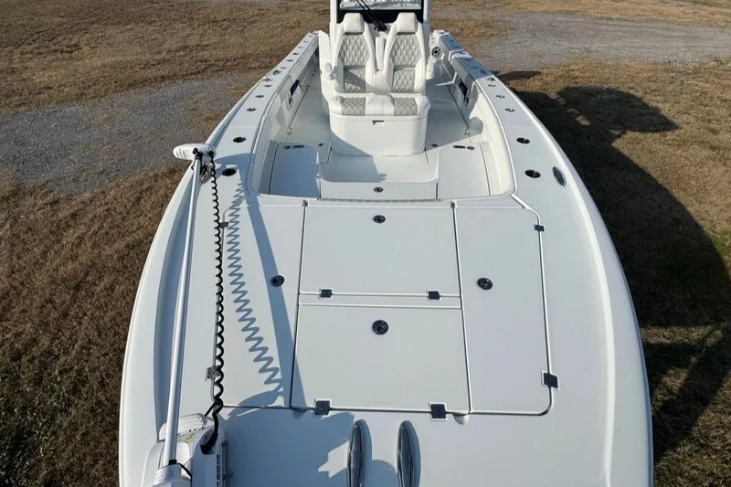 Slide: The Image of 2023 Freeman 28 boat with spacious deck and seating, parked on grass. - 8