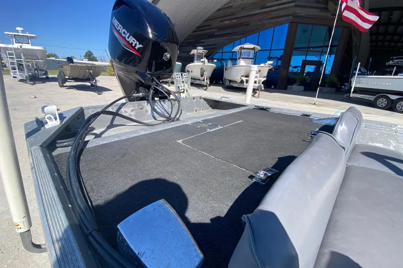 Slide: The Image of 1979 Monark 1648 Jon boat with Mercury engine, parked outdoors near showroom. - 13