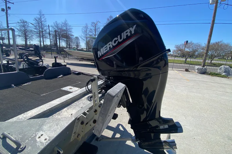 Slide: The Image of 1979 Monark 1648 Jon boat with Mercury outboard motor in a parking lot. - 15