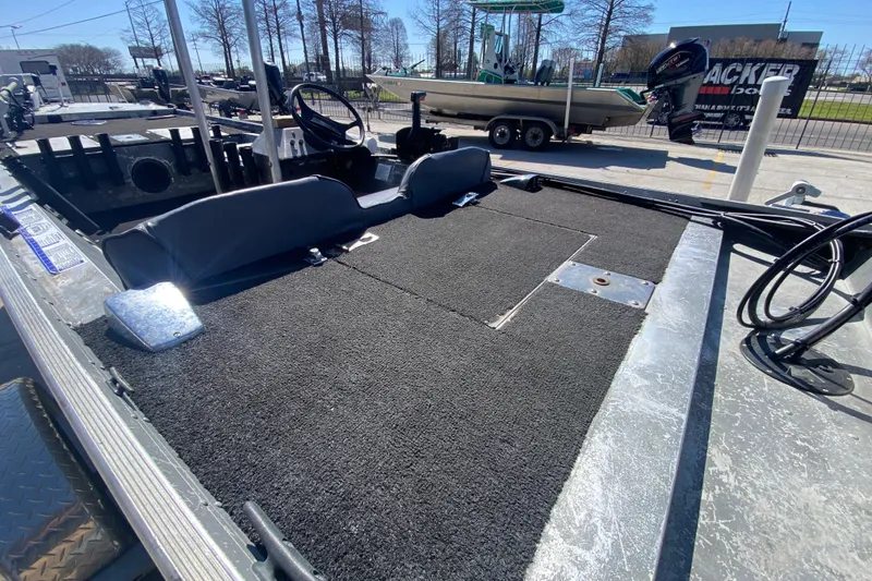 Slide: The Image of 1979 Monark 1648 Jon boat interior with carpeted deck and steering console. - 16