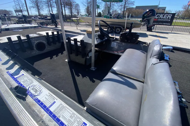 Slide: The Image of 1979 Monark 1648 Jon boat interior with seating and steering wheel, parked outdoors. - 17