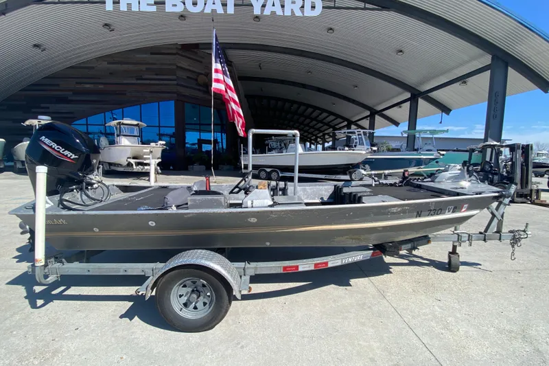 Slide: The Image of 1979 Monark 1648 Jon boat on trailer at The Boat Yard, with Mercury engine. - 2
