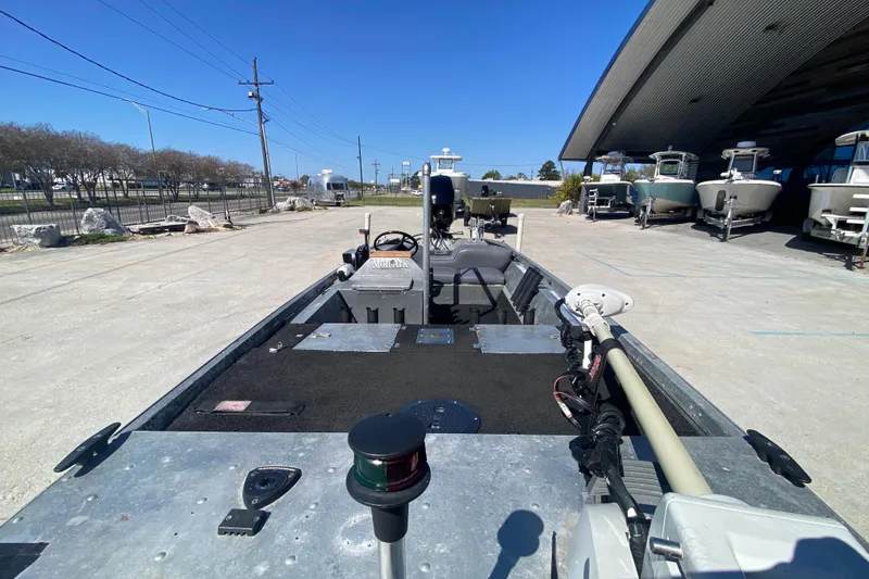 Slide: The Image of 1979 Monark 1648 Jon boat parked outdoors, showcasing interior and steering console. - 21