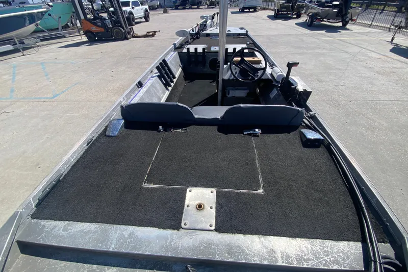 Slide: The Image of 1979 Monark 1648 Jon boat interior with steering wheel and seating, parked outdoors. - 22