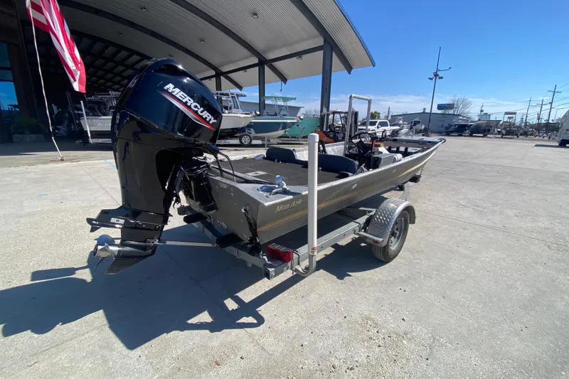 Slide: The Image of 1979 Monark 1648 Jon boat with Mercury engine on trailer, parked outdoors. - 3