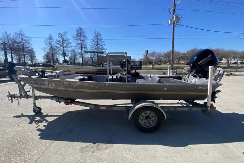 Slide: The Image of 1979 Monark 1648 Jon boat on trailer with Mercury outboard motor. - 6