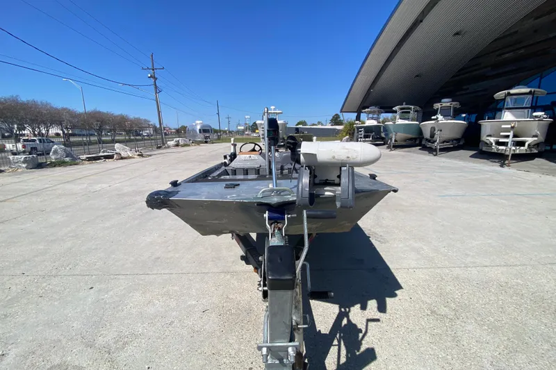 Slide: The Image of 1979 Monark 1648 Jon boat on trailer, parked outdoors under clear blue sky. - 8