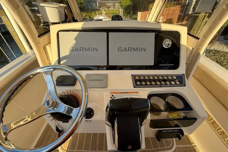 Slide: The Image of 2024 Scout 277 LXF boat dashboard with Garmin displays and steering wheel. - 10