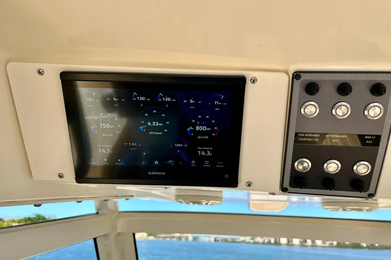 Slide: The Image of 2024 Scout 277 LXF boat dashboard with Garmin display and control panel. - 12